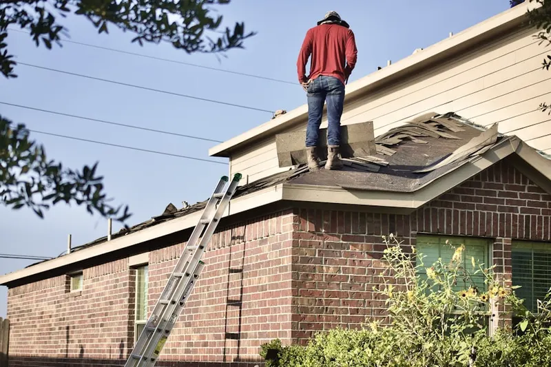Professional roofer working on a residential roof in South Randolph